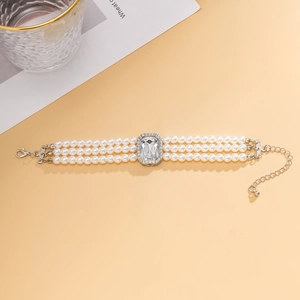 Détail du collier de perles à trois rangs avec pendentif en cristal et fermoir argenté