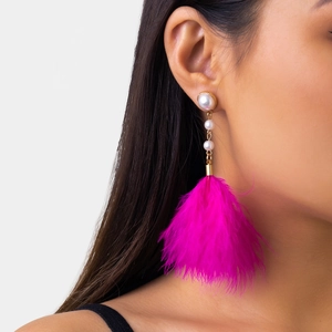 Detail of rose pink feather tassel earrings with pearls on a side profile model