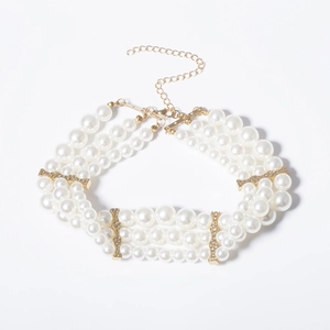 Détail du collier de perles à trois rangs avec entretoises dorées et fermoir mousqueton
