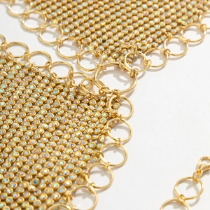 Macro view of gold metal mesh body chain with iridescent rhinestones and ring links