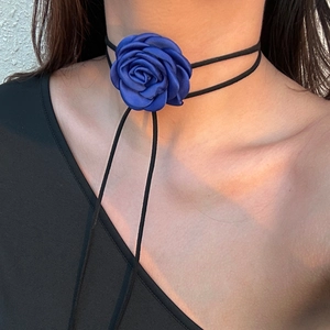 Detail van een handgemaakte choker met donkerblauwe satijnen roos en lang zwart koord