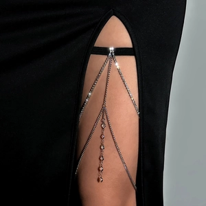 Macro detail of sexy sparkling rhinestone leg chain with elegant silver fringe tassels