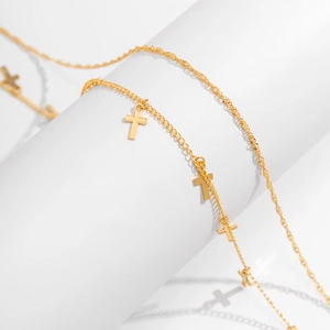 Detailed close-up of golden double-layer waist chain with delicate cross pendants