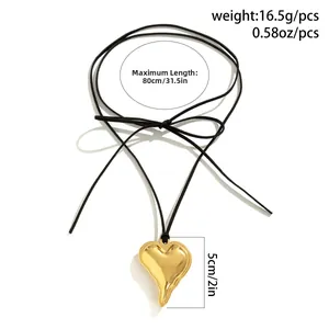 Detail view of large gold heart pendant showing dimensions and adjustable black cord length