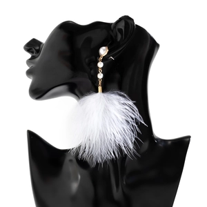 Detail of elegant gold chain earrings with white imitation pearls and fluffy ostrich feathers