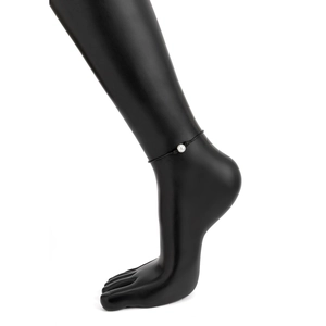 Tobillera minimalista de cordón negro con una sola perla blanca en pie de maniquí