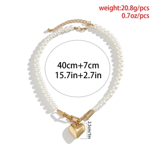 Détail du collier de perles avec pendentif cœur doré et chaîne d'extension réglable