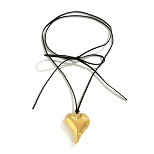 Detail of adjustable black velvet cord necklace with oversized gold lava heart pendant