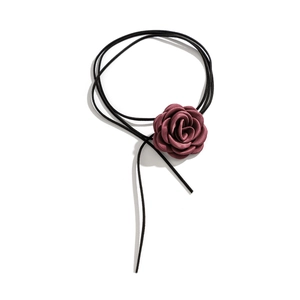Detailopname van een grote fluwelen roos stoffen bloem aan een dunne zwarte choker