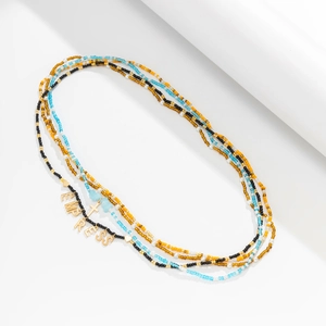 Detail of layered bohemian waist beads with EMPRESS charm and golden heart pendants