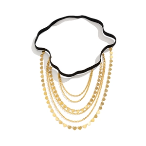 Detailed view of multilayer gold leg chain with heart charms on black elastic band