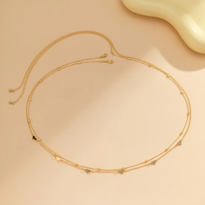 Detail of double-layer gold waist chain with heart pendants and lobster clasp