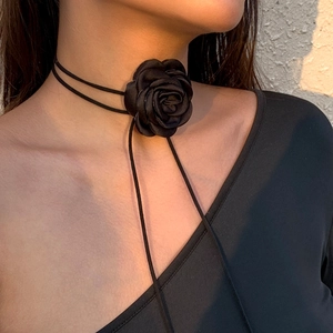 Gedetailleerde macro-opname van een zwarte 3D roos choker met elegante fluwelen linten