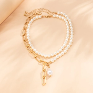 Détail d'un collier à couches dorées avec perles blanches et pendentif perle baroque