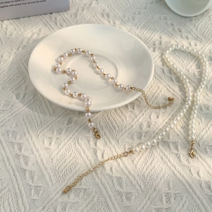 Vue détaillée de l'ensemble collier et bracelet en perles avec fermoirs dorés