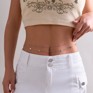 Detail of double-layer silver body chain with five hollow star charms on model waist