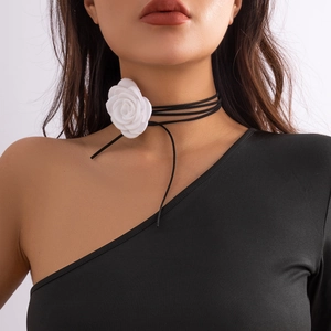 Detail van een witte 3D-stoffen roos op een zwarte meerstrengs fluwelen choker ketting