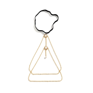 Detail of gold multi-layer thigh chain with black elastic band and white pearl charms