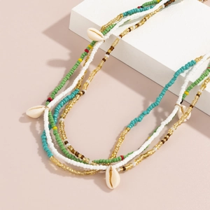 Detail of colorful bohemian waist beads and white sea shells on a beach body chain set