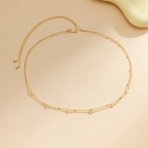 Detailed view of double-layer gold waist chain with polished star charms and lobster clasp