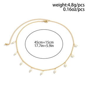 Detail view of gold layered necklace with pearl drop charms and lobster clasp closure
