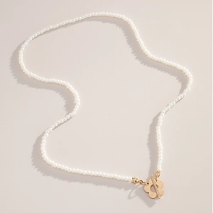 Détail d'un collier de perles élégant avec fermoir à bascule doré en fleur