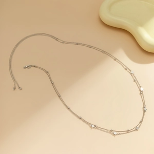 Detail of silver double-layered body chain featuring star charms and beaded accents