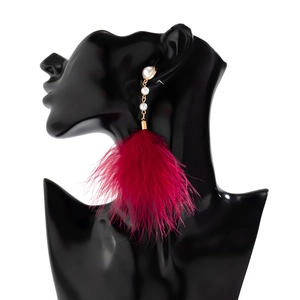 Detailed close-up of long burgundy feather tassel earrings with elegant white pearls