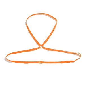 Gros plan du harnais de corps orange élastique avec boucles et anneaux en métal doré