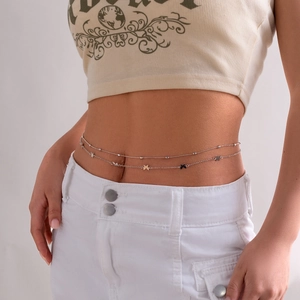Close-up of double-layered silver body chain with star pendants on a fashion model