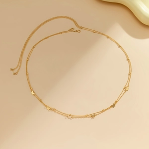 Detail of a golden double-layered body chain featuring delicate butterfly pendants