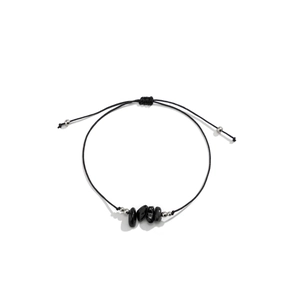 Detalle de pulsera ajustable de cordón negro con piedras negras pulidas y cuentas plateadas