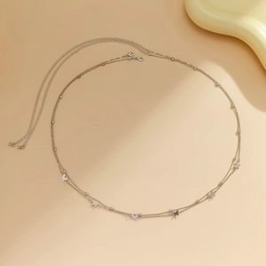 Detail of silver double-layered butterfly waist chain with metal beads on beige background