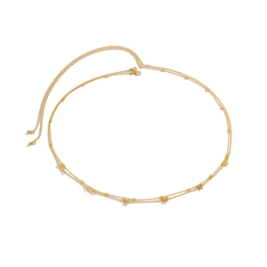 Detail of double-layer gold snake chain body jewelry with star charms and lobster clasp