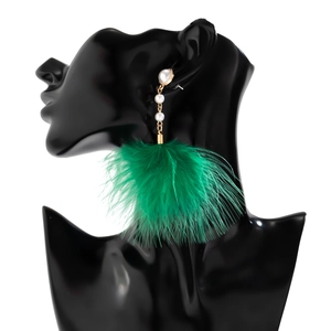 Detail of long drop earrings featuring green feather fringe and white faux pearls