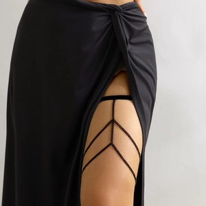 Close-up of a multi-layer black leg chain with elastic thigh band on a model