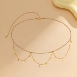 Detail of gold layered body chain with sparkling rhinestones and star charms