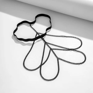 Detail of layered black metal chains and elastic thigh band with punk style aesthetics