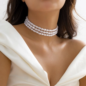 Collier ras du cou à trois rangées de perles et pendentif cœur porté par un mannequin