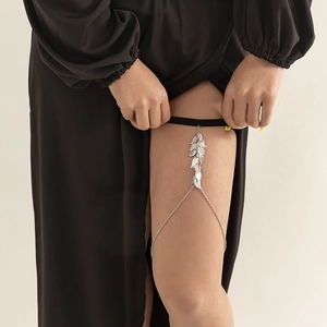 Detailed silver leaf thigh chain with elastic band and draped metal fringe on model