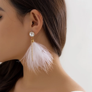 Detail of long feather tassel earrings with sparkling crystals and elegant gold chains