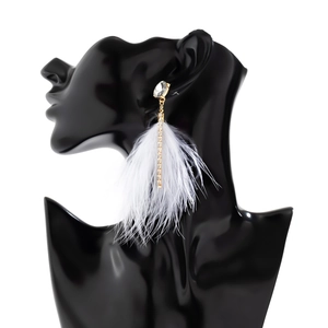 Detail of long feather tassel earrings with sparkling rhinestones and gold-tone plating