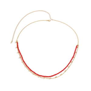 Detail of double-layer gold waist chain with red beads and sparkling rhinestone accents