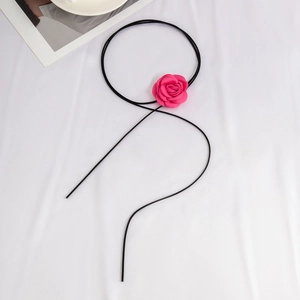 Detailopname van een roze zijden roos op een zwarte fluwelen choker halsketting