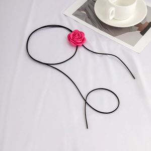 Platliggende roze stoffen roos choker op een elegante witte gedrapeerde achtergrond
