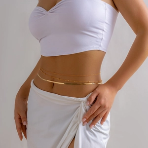 Detail of gold layered waist chain featuring a flat snake bone chain and bead link design