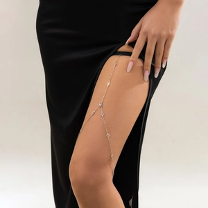Detailed view of silver leg chain with sparkling rhinestones on black elastic band