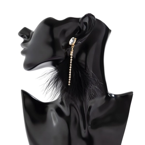 Detailed view of long tassel earrings with black feathers and sparkling crystals