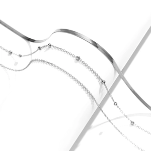 Detailed view of silver layered snake chain and delicate beaded metal body chains