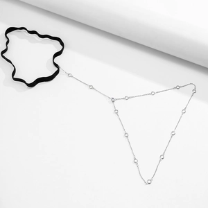 Close-up of black elastic leg chain with silver metal links and circular metal rings